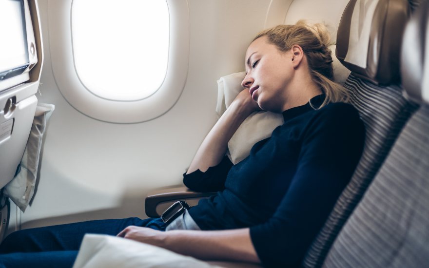 donna che dorme in aereo per alleviare sintomi jet lag